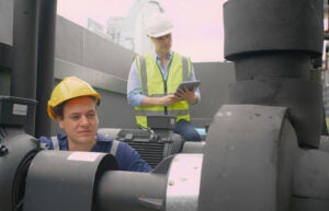 Two workers examining a pump.